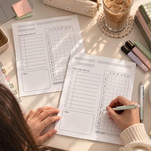 Puede incluir: Dos hojas de papel para planificador diario con una sección de código de colores y lista de tareas, una cuadrícula de bloques de tiempo de 7 a 21 y un cuadro de notas. Una hoja se está completando con un bolígrafo sobre un escritorio.