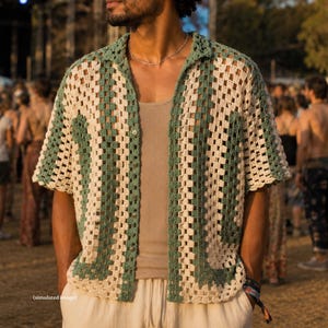 Può includere: Una camicia a maniche corte con bottoni caratterizzata da un motivo a uncinetto granny square con strisce verticali alternate color verde salvia e crema. La camicia presenta un colletto classico, un'abbottonatura frontale e una trama aperta.