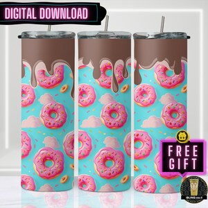 以下が含まれることがあります： 青い背景にチョコレートのアイシングとスプリンクルをかけたピンクのドーナツのデザインが施された、ステンレス製のタンブラー3個。タンブラーは昇華転写用です。