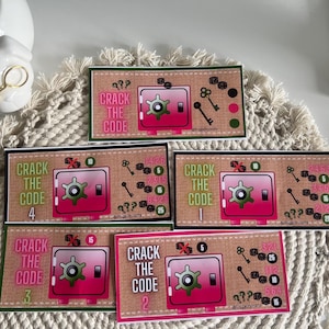 Könnte beinhalten: Karten mit einem rosa Tresor-Design und dem Text "CRACK THE CODE". Jede Karte zeigt eine andere Nummer, Schlüssel und Punkte. Die Karten liegen auf einer strukturierten, cremefarbenen Oberfläche.