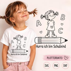 Könnte beinhalten: Ein weißes T-Shirt mit einer schwarzen Strichzeichnung eines Mädchens mit Zöpfen, das auf einem großen Bleistift steht, umgeben von den Buchstaben A, B, C und Herzen. Unter dem Bleistift steht der Text Hurra ich bin Schulkind in Schwarz.
