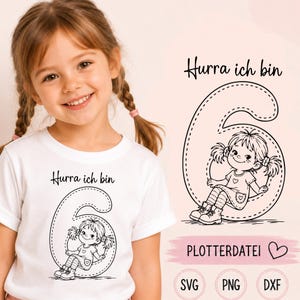 Może przedstawiać: Biała koszulka z czarną grafiką liniową przedstawiającą dziecko siedzące wewnątrz dużej cyfry sześć, z napisem Hurra ich bin powyżej. Ta sama grafika i tekst są pokazane oddzielnie po prawej stronie, wraz z etykietami SVG, PNG oraz DXF.