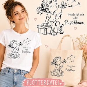 Può includere: Una t-shirt bianca e una borsa tote beige con un'illustrazione a linee nere di un bambino seduto su una panchina che soffia su un dente di leone. Il design include il testo in tedesco "Heute ist mir alles Pusteblume" e piccoli cuori rosa.