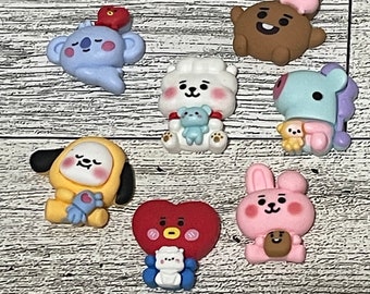 May include: A set of eight colorful cartoon character charms, each featuring a different character with a unique expression and pose. The charms are made of a soft, pliable material and are perfect for adding a touch of whimsy to any project.