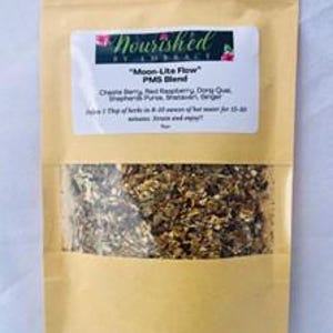 Könnte beinhalten: Ein brauner Papierbeutel mit einem Sichtfenster, das eine Mischung aus getrockneten Kräutern zeigt. Das Etikett lautet "Nourished by Liberty" und "Moon-Lite Flow PMS Blend". Die aufgeführten Zutaten sind: Krampfrinden, Himbeere, Dong Quai, Frauenmantel, Rein, Wild gesammelt, Ingwer.