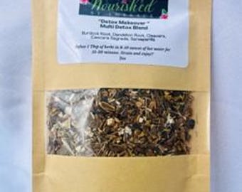 May include: A brown paper bag with a white label that reads "Detox Maintenance Multi Detox Blend" and lists the ingredients: Burdock Root, Dandelion Root, Cleavers, Cascara Sagrada, Horsetail, and more. The bag contains a blend of dried herbs.