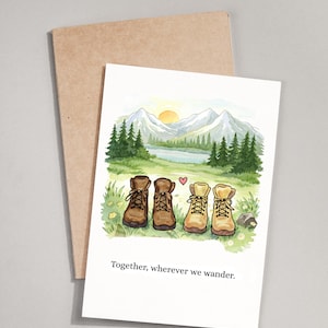 May include: Greeting card with a watercolor illustration of four hiking boots in a field with a mountain landscape background. The text "Together, wherever we wander" is printed below the boots. A brown envelope is behind the card.