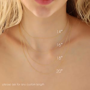 May include: Four delicate gold necklaces of varying lengths, 14, 16, 18, and 20 inches, are displayed around a person's neck. The image shows the necklaces' different lengths. The text at the bottom says, "please ask for any custom length."