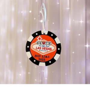 Peut inclure: Ornement en forme de jeton de casino, avec un ruban blanc. Le centre orange affiche "LAS VEGAS NEVADA" et "JULY 2,3&5 2025". L'anneau extérieur est noir et blanc, rappelant un jeton de poker.