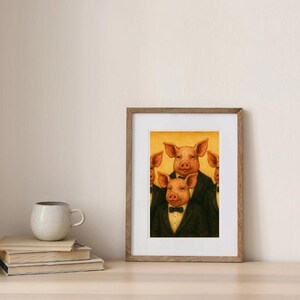 Puede incluir: Impresi&oacute;n art&iacute;stica enmarcada que presenta cuatro cerdos antropom&oacute;rficos con esmoquin negro y pajarita. Los cerdos tienen piel rosada y est&aacute;n sobre un fondo amarillo. La obra de arte est&aacute; en un marco de madera.