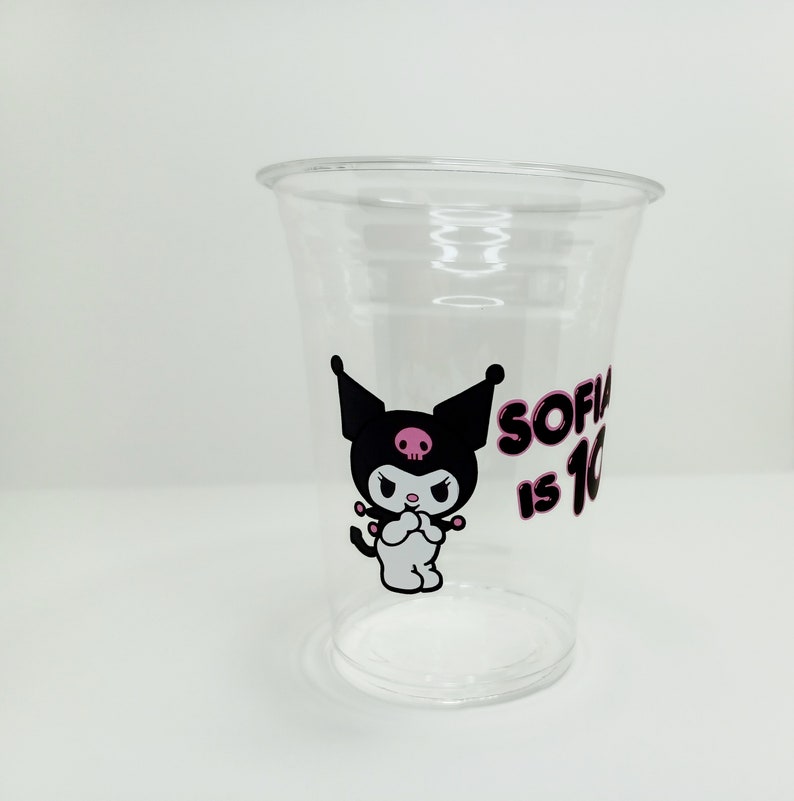 Puede incluir: Vaso de pl&aacute;stico transparente con un personaje de dibujos animados en blanco y negro con una calavera rosa y el texto "Sofia is 10" en rosa.