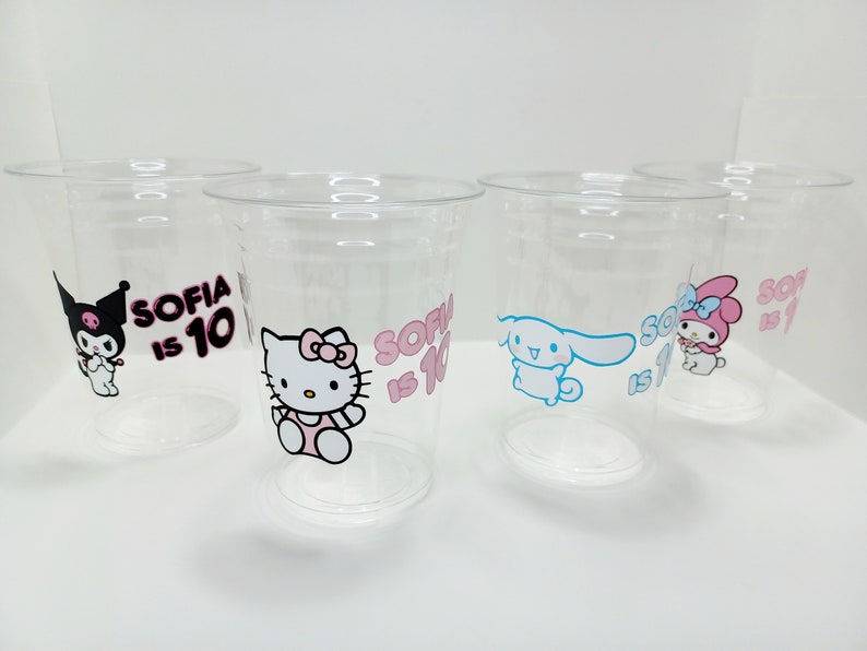 Puede incluir: Cuatro vasos de pl&aacute;stico transparente con dise&ntilde;os de personajes de dibujos animados coloridos y el texto "Sofia tiene 10 a&ntilde;os" impreso en ellos.