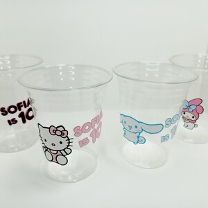 Puede incluir: Cuatro vasos de pl&aacute;stico transparente con dise&ntilde;os de personajes de dibujos animados coloridos y el texto "Sofia tiene 10 a&ntilde;os".