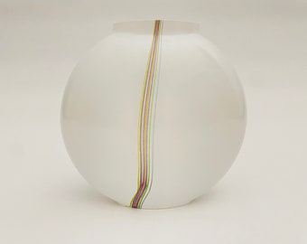 May include: A white, spherical vase with a vertical stripe of colourful lines. The lines include shades of red, yellow, green, and purple. The vase has a smooth, glossy finish and a rounded shape.