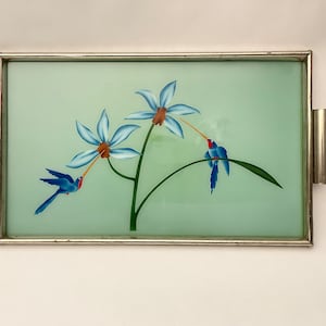 Może przedstawiać: Prostokątny podtalerz z jasnozielonym tłem i kwiatowym wzorem. Wzór przedstawia niebieskie kwiaty i niebieskie ptaki z czerwonymi dziobami. Taca ma srebrną metalową ramę i uchwyty.