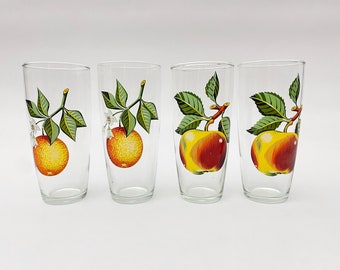 Könnte beinhalten: Vier transparente Gläser mit Fruchtdarstellungen. Zwei Gläser zeigen Orangen mit grünen Blättern und weißen Blüten. Die anderen beiden Gläser haben Äpfel mit grünen Blättern und roter und gelber Farbe.