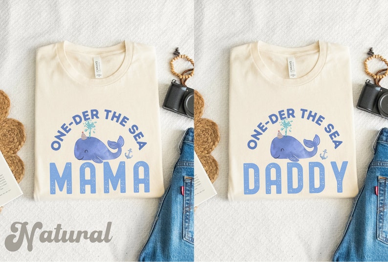 May include: Two cream colored t-shirts with a blue whale graphic and the text "One-der the Sea" with the words "Mama" and "Daddy" below the whale.