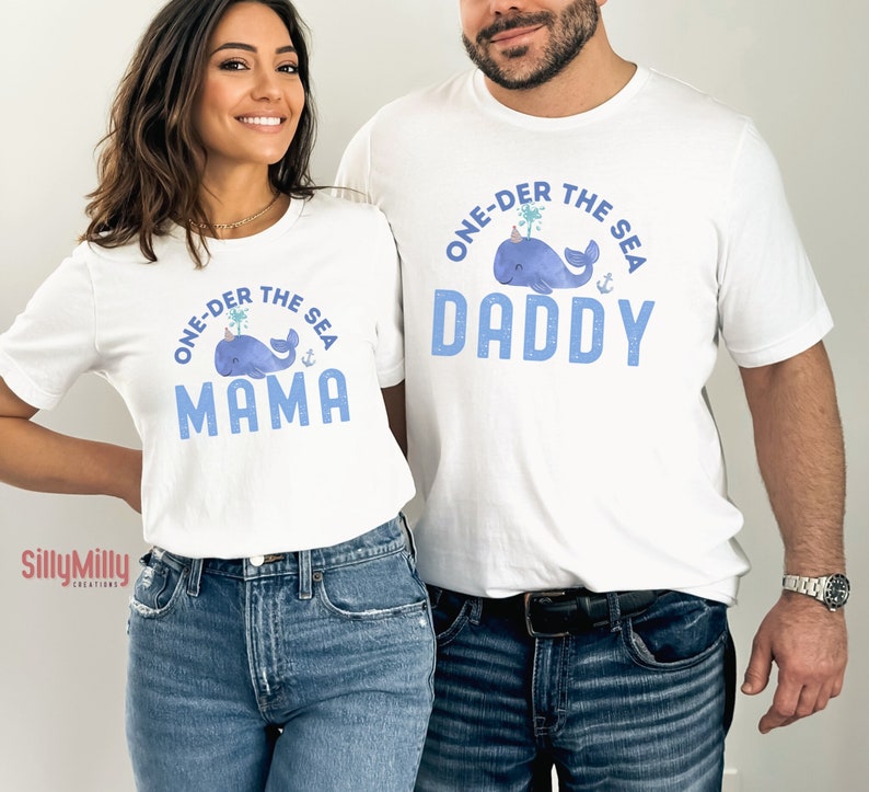 May include: White t-shirts with blue text and a whale graphic. The text on the shirts reads "One-der the Sea" with "Daddy" and "Mama" below the whale graphic.