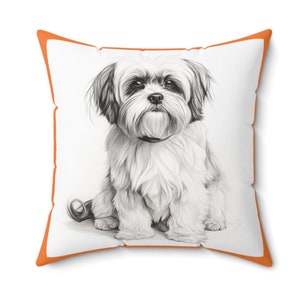 May include: A white and gray  Shih Tzu dog is sitting on a white pillow with an orange border. The dog is looking directly at the camera.