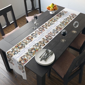 Może przedstawiać: Biały bieżnik stołowy z kolorowym wzorem gnomów trzymających pisanki wielkanocne i kwiaty. Tekst "Happy Gnome Easter" jest powtarzany wzdłuż bieżnika.