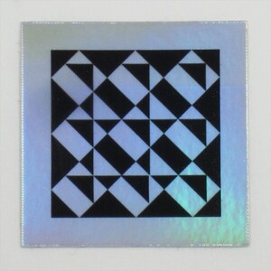 May include: A black and white geometric pattern with a repeating design of triangles and squares. The pattern is on a silver background with a slight iridescent sheen.