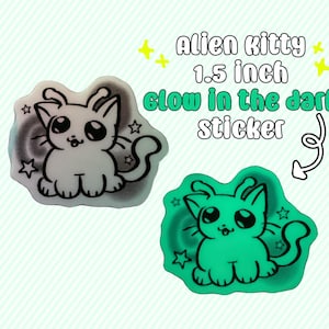 May include: Two stickers featuring an alien kitty design. The stickers are 1.5 inches and glow in the dark. One sticker is white with a black outline, and the other glows green. Text on the image reads "Alien kitty 1.5 inch glow in the dark sticker."