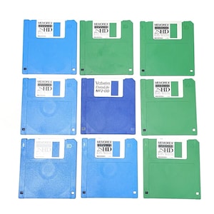 Puede incluir: Nueve disquetes vintage de 3,5 pulgadas en azul y verde. Los discos tienen etiquetas con el logotipo "MEMOREX 2SHD". Un disco está etiquetado "Verbatim DataLife MF2-DD". Los discos están dispuestos en una cuadrícula.