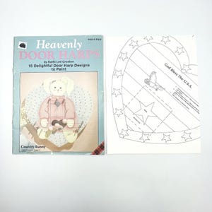 May include: A book titled "Heavenly Door Harps" by Kathi Lee Croxton, featuring 15 door harp designs to paint. The cover shows a Country Bunny design. Next to it is a heart-shaped template with stars and the text "God Bless The U.S.A."