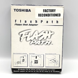 May include: A white and blue Toshiba FlashPath Floppy Disk Adapter box. The box features the text "FlashPath" in a stylized font, with the words "Floppy Disk Adapter" below. The box also has the text "Factory Reconditioned".