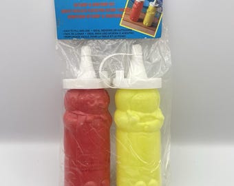 Set vintage anni '90 di ketchup e senape Hartin con bottigliette a forma di personaggio, nuove nella confezione originale.