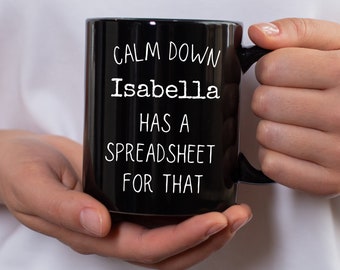 May include: Black coffee mug with white text that reads "Calm down Isabella has a spreadsheet for that."
