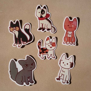 May include: Set of six colorful cat stickers with different expressions and poses. The stickers feature a black and white cat with a red bandana, a red and white cat with a red bandana, a black and white cat with a red bandana, a black and white cat with a red bandana, a black and white cat with a red bandana, and a black and white cat with a red bandana.