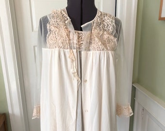 May include: A white sheer nightgown with a lace overlay and long sleeves. The nightgown has a button-up front and a tie at the waist.