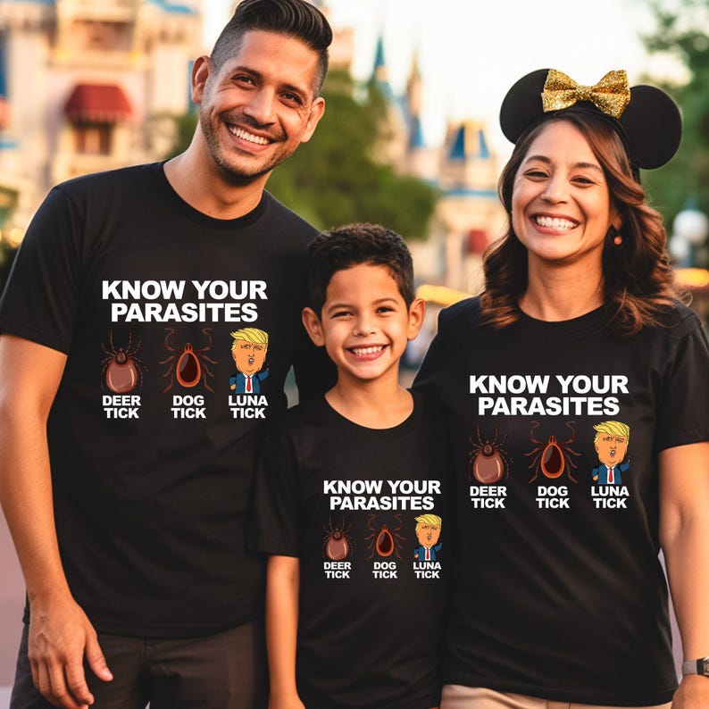 K&ouml;nnte beinhalten: Schwarze T-Shirts mit dem Text "KNOW YOUR PARASITES" und Illustrationen einer Hirschzecke, einer Hundezecke und einer Cartoonfigur. Die Shirts werden von einer dreik&ouml;pfigen Familie getragen.