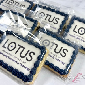 May include: A close-up of several individually packaged cookies decorated with blue icing and the company logo "LOTUS MANAGEMENT SERVICES, INC. Business Clarity Empowered by Technology".