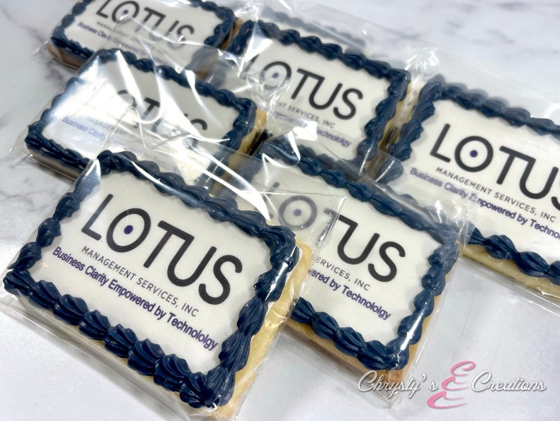 May include: A close-up of several individually packaged cookies decorated with blue icing and the company logo "LOTUS MANAGEMENT SERVICES, INC. Business Clarity Empowered by Technology".