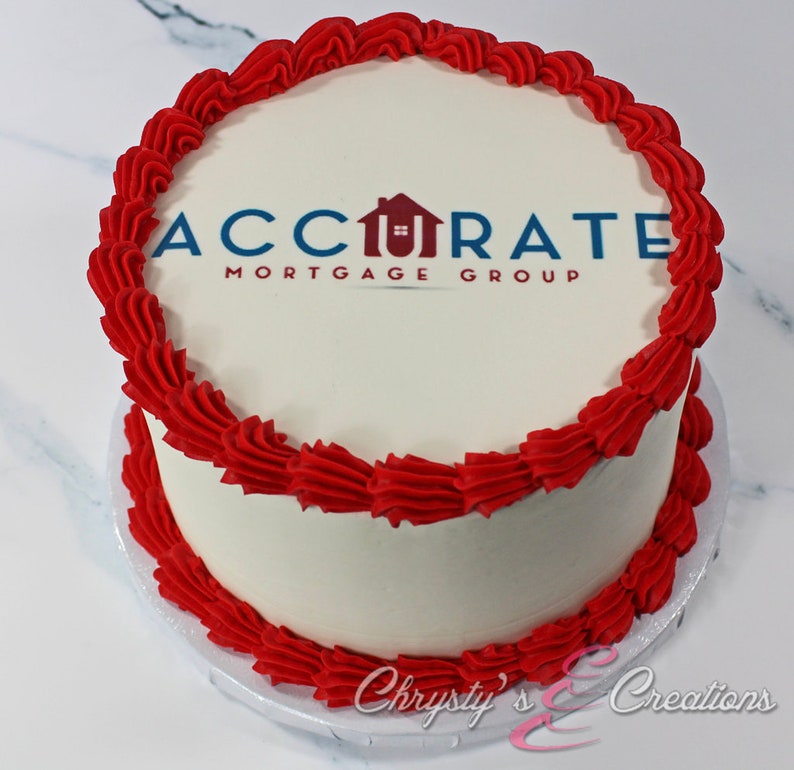 May include: A white cake with red frosting and a printed logo that says "Accurate Mortgage Group" on top.