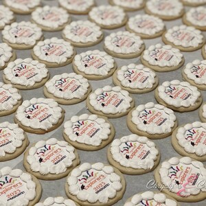 May include: A tray of decorated sugar cookies with white frosting and colorful designs. The cookies are decorated with the text "Explorers 2023 Graduate!"