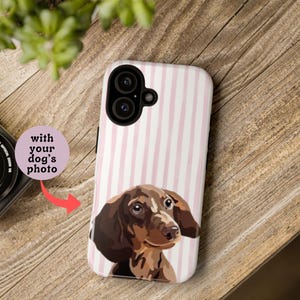 May include: A phone case with a pink and white striped background and a portrait of a dachshund dog. The text "with your dog's photo" is on a pink circle.