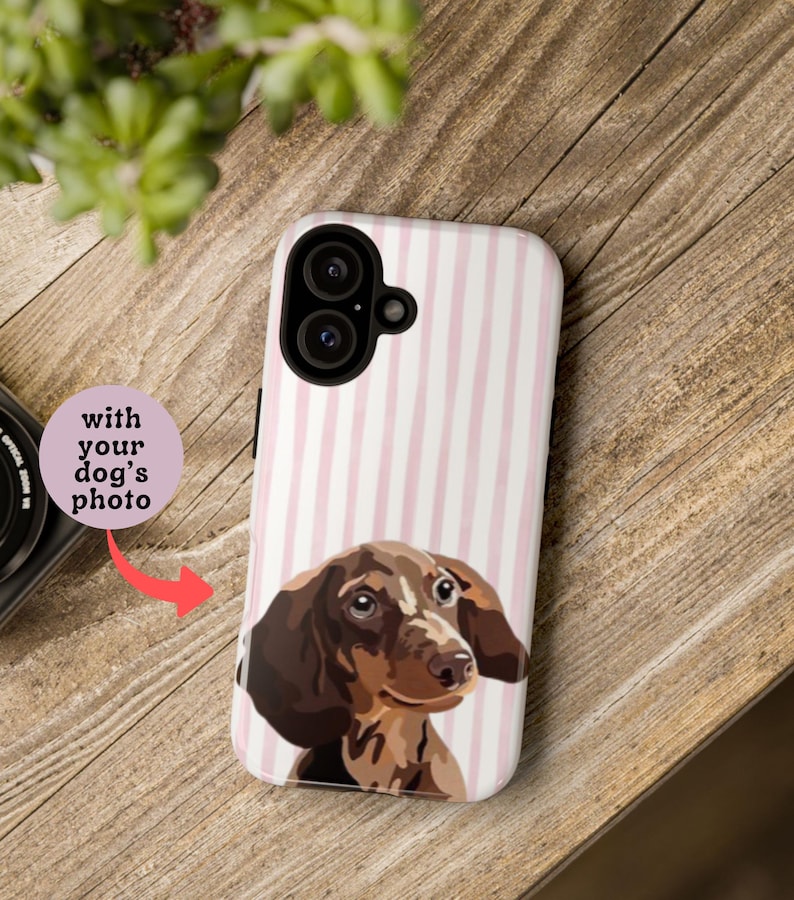 May include: A phone case with a pink and white striped background and a portrait of a dachshund dog. The text "with your dog's photo" is on a pink circle.