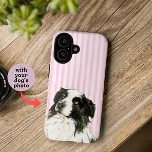 May include: A phone case with a pink and white striped pattern and a watercolor-style portrait of a black and white dog. The case has a camera cutout and the text "with your dog's photo".