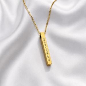 May include: A gold-toned vertical bar pendant necklace featuring a delicate chain. The rectangular bar is engraved with the black text In My Dirty Thirty Era, positioned vertically along the front surface of the polished metal pendant.