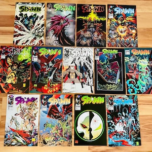 May include: A collection of twelve Spawn comic books arranged in three rows. Each cover features colorful, detailed illustrations of the character Spawn, including various action scenes, close-ups, and graphic designs with the title Spawn displayed.