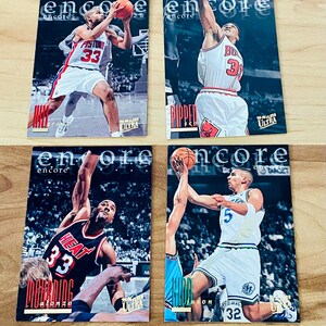 May include: Four basketball trading cards featuring NBA players. The cards are from the 1997-98 Fleer Ultra set. The players featured are Grant Hill,  Scottie Pippen, Alonzo Mourning, and Jason Kidd.