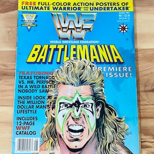 May include: A vintage "Battlemania" comic book cover featuring a wrestler with face paint. The cover is predominantly blue with yellow and white text, including "World Wrestling Federation" and "Premiere Issue!"