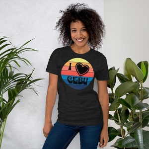 May include: A dark heather grey t-shirt with a retro-style graphic of a sunset with a heart and the text "I love Cebu".
