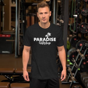 May include: A black t-shirt with a white graphic design featuring palm trees and the text "PARADISE Giftshop".