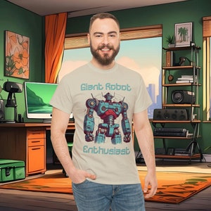 May include: A light beige t-shirt with a graphic of a blue and red robot with the text "Giant Robot Enthusiast" printed on the front.