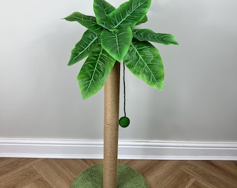May include: A green palm tree cat scratching post with a sisal rope covered pole and a green fuzzy base. A dangling green ball hangs from the pole.