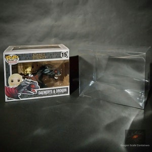 May include: A clear plastic protector box for a Game of Thrones Pop! Vinyl figure of Daenerys Targaryen riding Drogon. The box is labeled "Daenerys & Drogon" and features a picture of the figure inside.